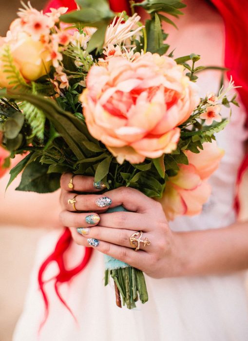 ramo de rosas sostenido por las manos de una mujer con uñas postizas 
