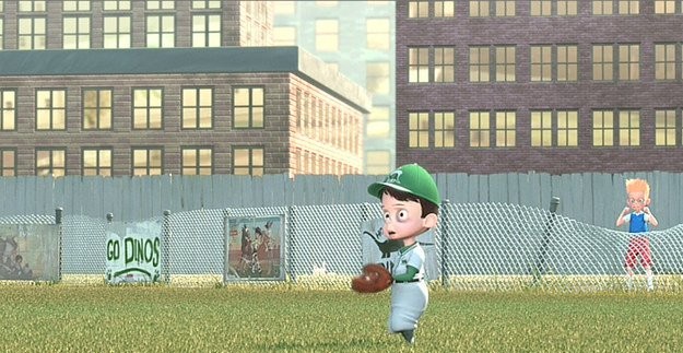 niño de cinco años jugando beisbol en un campo atrás de unos edificios 
