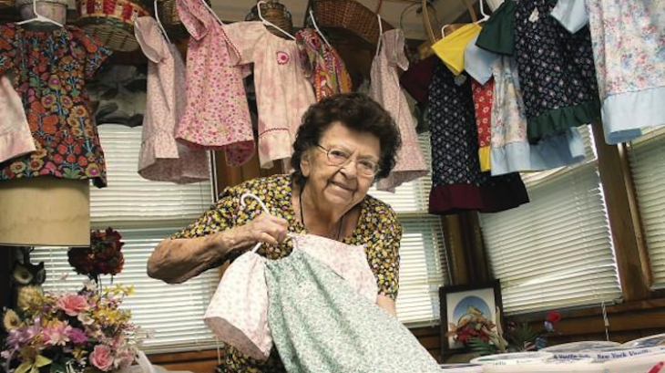 Lillian Weber rodeada de algunos vestidos hechos por ella 