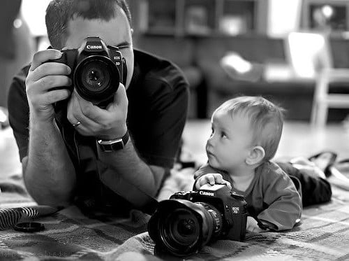 papá fotógrafo con cámara y su bebé también 