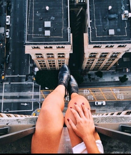 piernas de chica que está sentada en la azotea de un edificio 