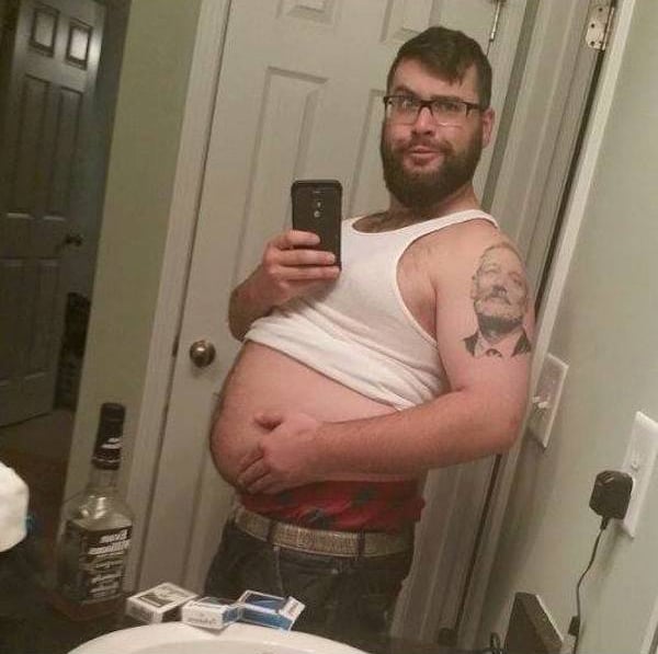 man holding his belly while taking a picture 