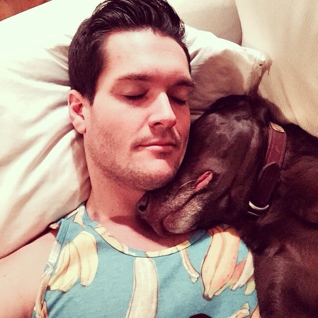 man sleeping next to his dog 