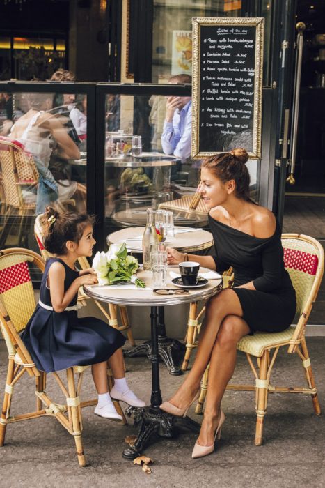 madre e hija sentadas en una mesa comiendo 