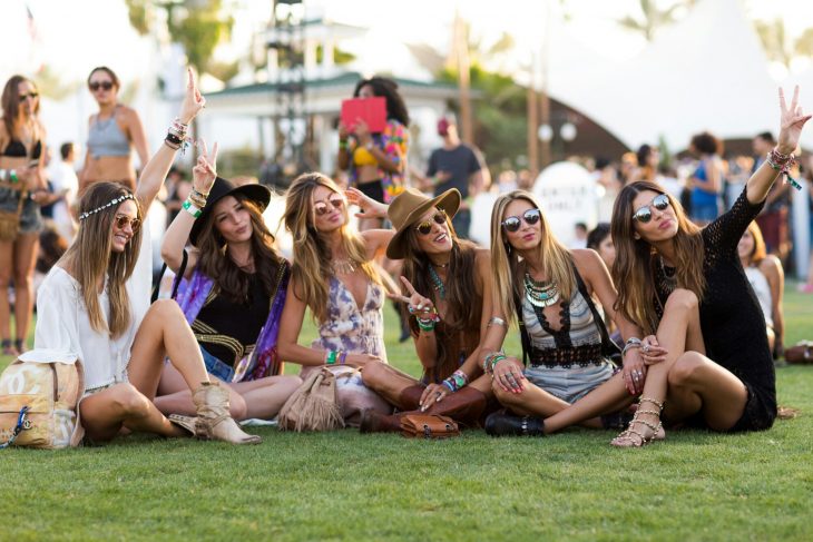Chicas sentadas en el pasto en el festival de coachella 2015
