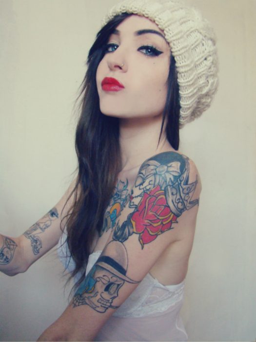 Chica de labios rojos y brazos tatuados