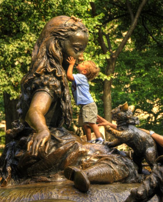 Niño besando a una estatua en la boca