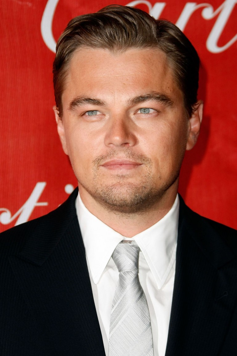 Leonardo DiCaprio usando un traje negro, una camisa blanca y una corbata en color gris