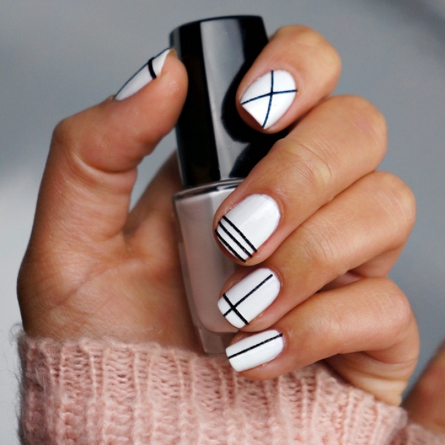 Uñas con diseños minimalistas en color blanco con líneas en color negro