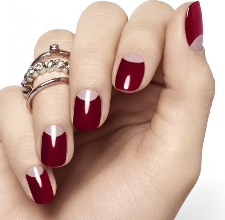 Mitad de una uña pintada de color rojo