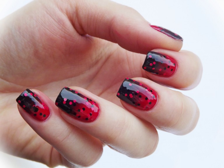 Uñas de color rojo con glitter de color negro