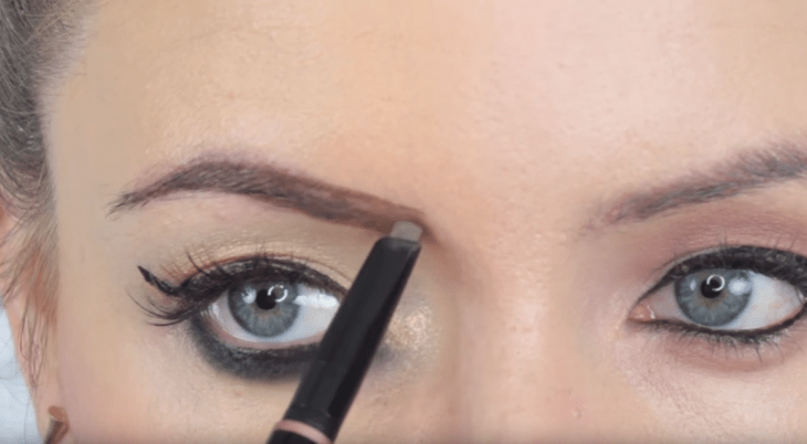 chica maquillando sus cejas con pincel