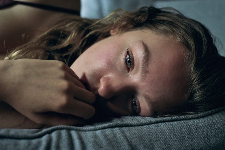 Chica recostada en la cama llorado 