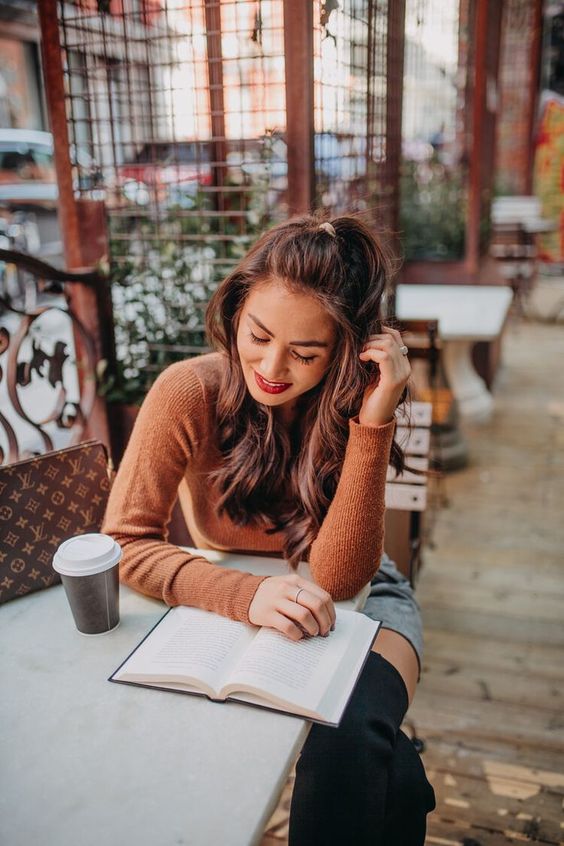 Chica en una cafetería leyendo un libro 