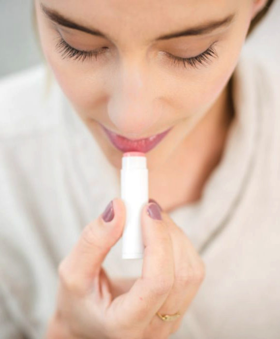 Mujer aplicando bálsamo labial Labello