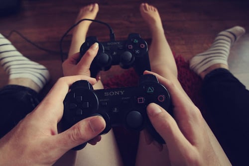 manos de hombre y mujer sosteniendo un control de videojuego 