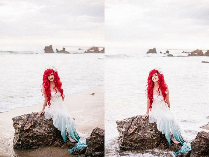 mujer vestida de blanco con cabello rojo sentada en una roca a un lado del mar 