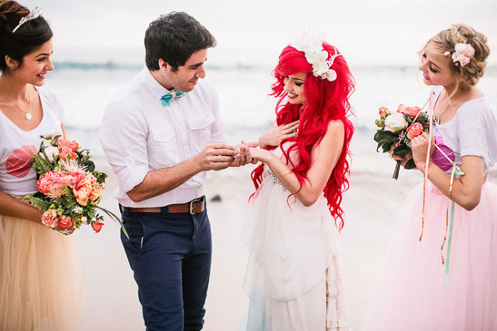 pareja casandose frente al mar mientras son acompañados por las damas de honor 