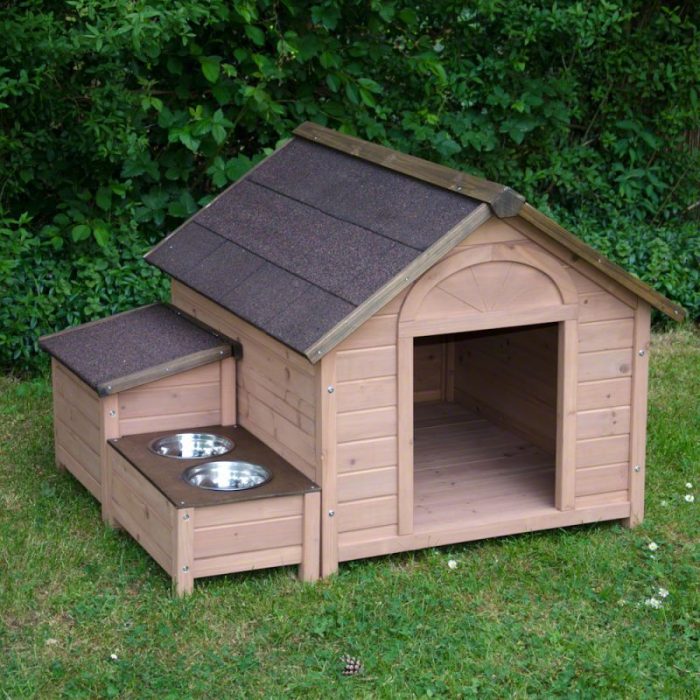 Casitas de perro con platos de comida a un costado 