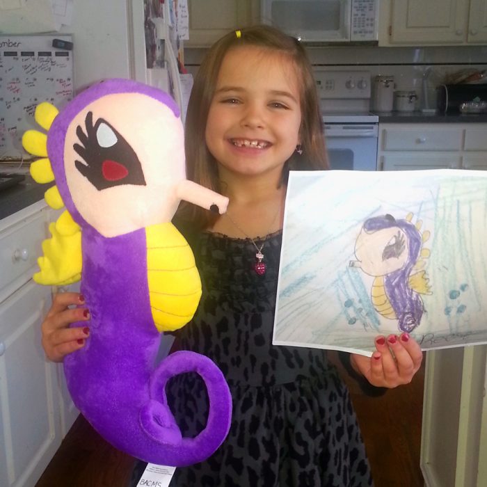 Niña con su dibujo y su peluche de budsies 