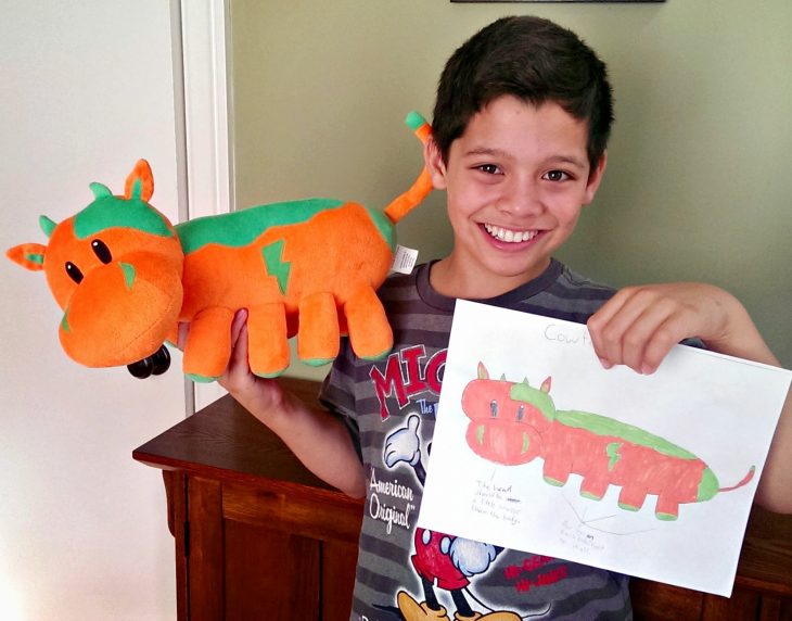 Niño feliz con su dibujo y peluche de budsies 