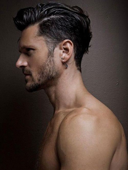 hombre de perfil con barba y cabello corto y un seguro en la oreja 