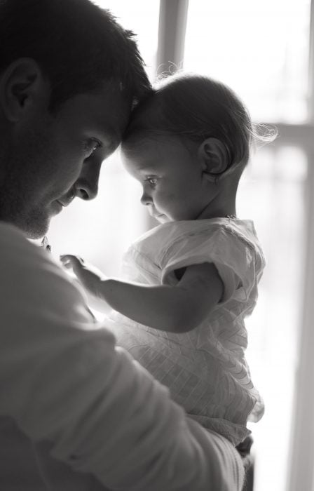 Foto en blanco y negro de papá cargando a su pequeña hija 