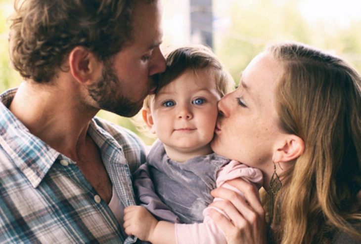 niña en medio de sus papás felices 