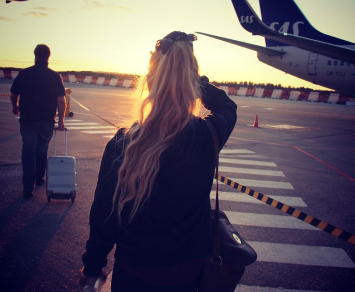 mujer a punto de abordar un avión con la puesta de sol 