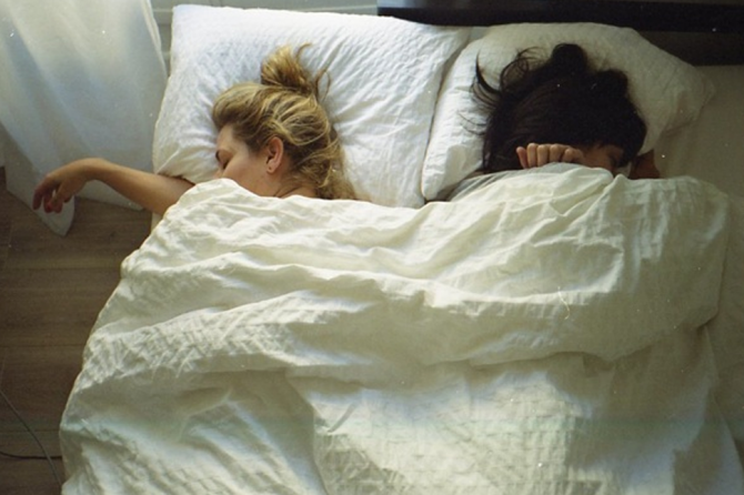 amigas acostadas en la cama durmiendo 