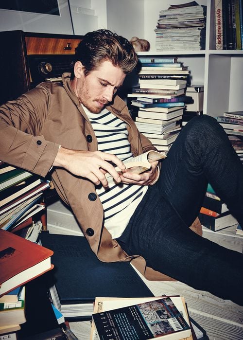 hombre sentado entre libros leyendo 