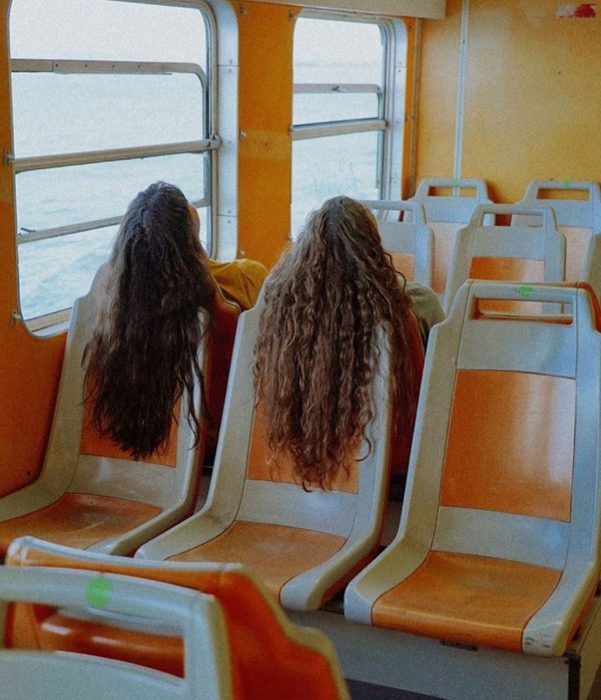 Chicas de cabello suelto y largo viajando en tren 