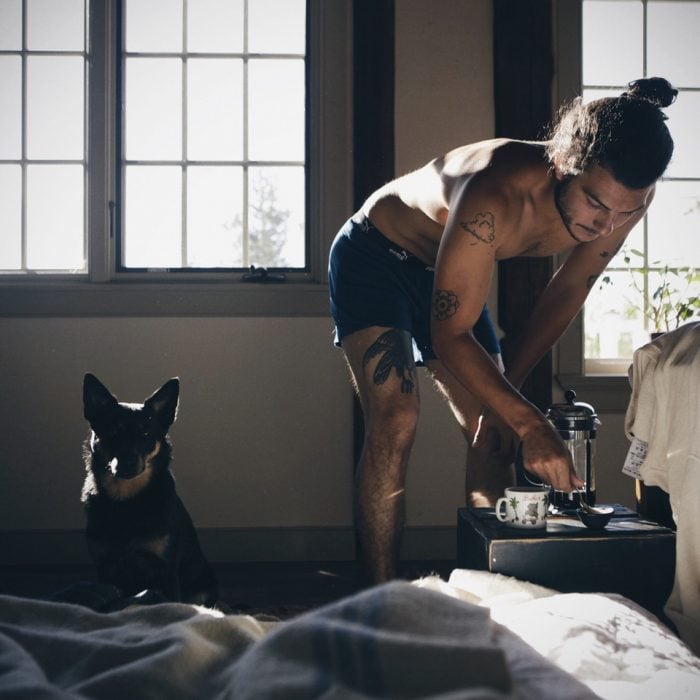 Hombre preparando café con su perro