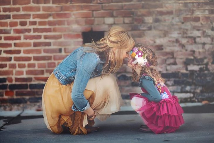 mamá e hija agachadas topando su nariz 