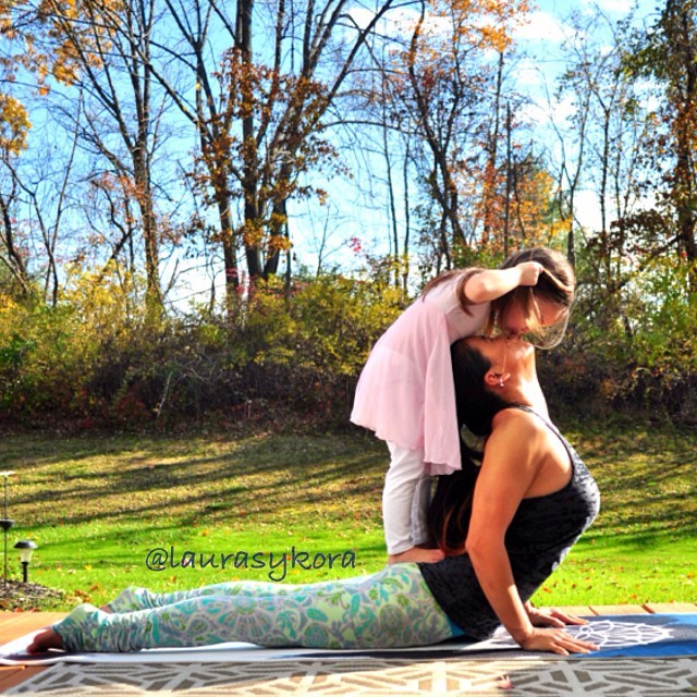 Madre e hija dándose un beso en un paso de yoga 