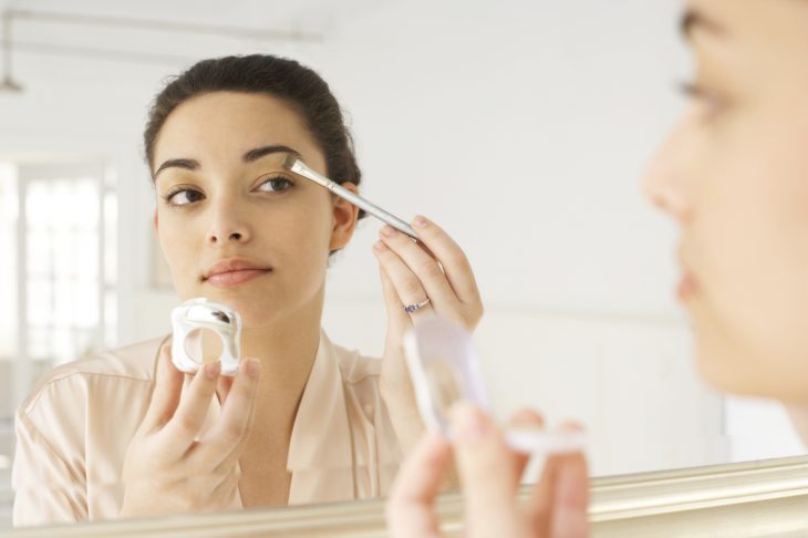 Mujer frente a un espejo pintÃ¡ndose un ojo 