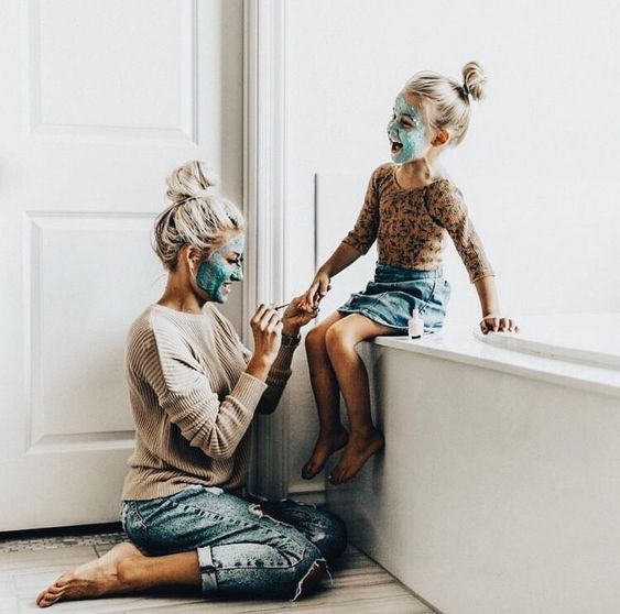 Madre e hija con mascarillas en el baño