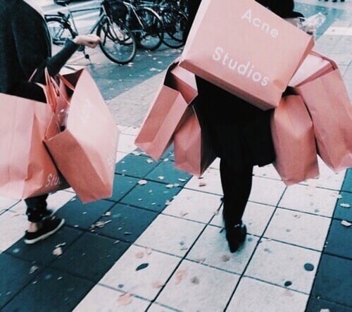Mujeres caminando con bolsas rosas de compras