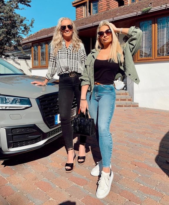 Madre e hija posando frente a un automóvil