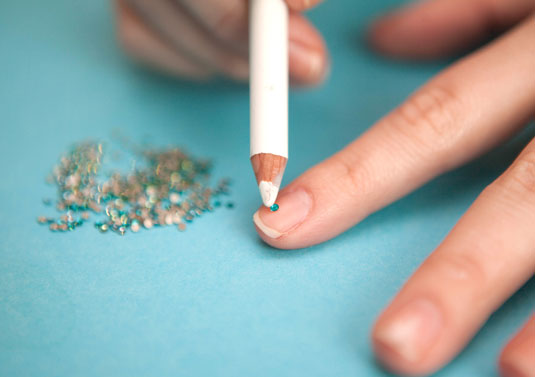 Colocando diamantes con delineador en las uñas