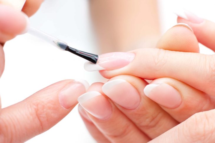 Aplicando base transparente en las uñas