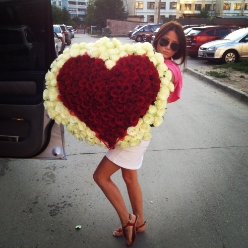 mujer sosteniendo un ramo de rosas en forma de corazón