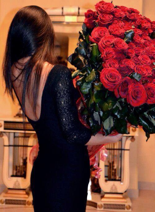 chica cargando un ramo de rosas vestida de negro 