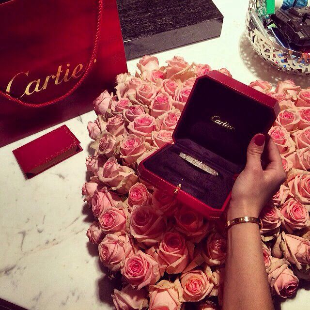 ramo de rosas con una joya de cartier frente a ellas