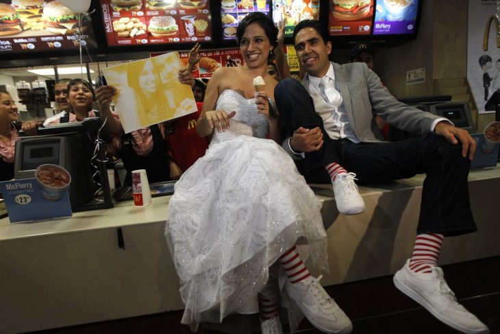 novios sentados en la barra de mcdonald's mientras comen un helado 