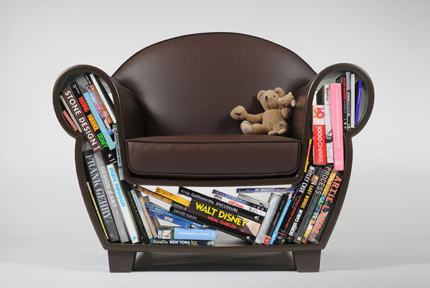 sofá con distintos libros y un oso de felpa sobre el 