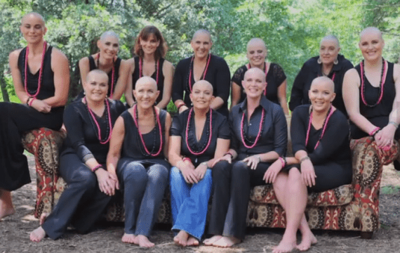 grupo de amigas con la cabeza rapada vestidas de negro con collares rosa 