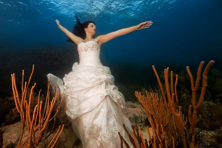 novia bajo el agua con brazos extendidos 