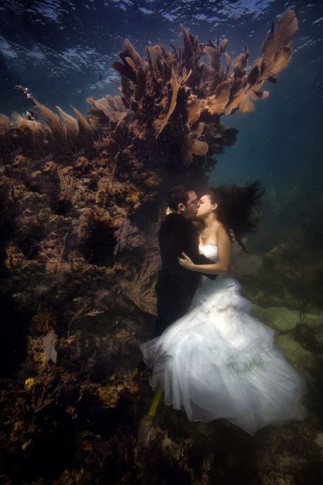 novios besandose bajo el agua 