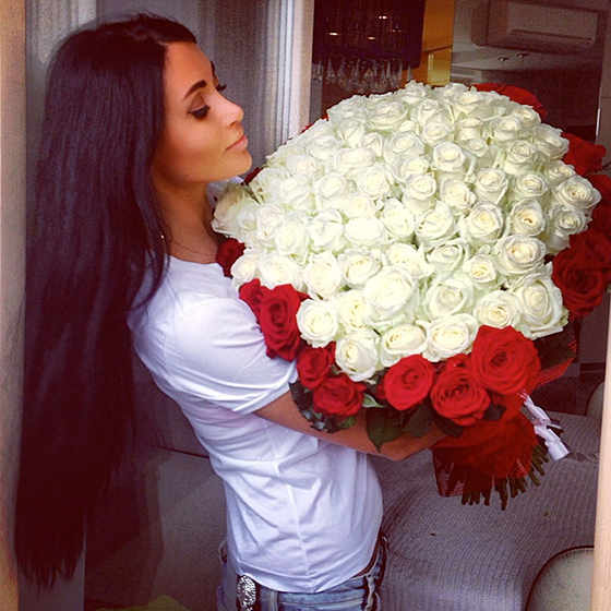 chica de cabello largo cargando un ramo gigante de rosas blancas 